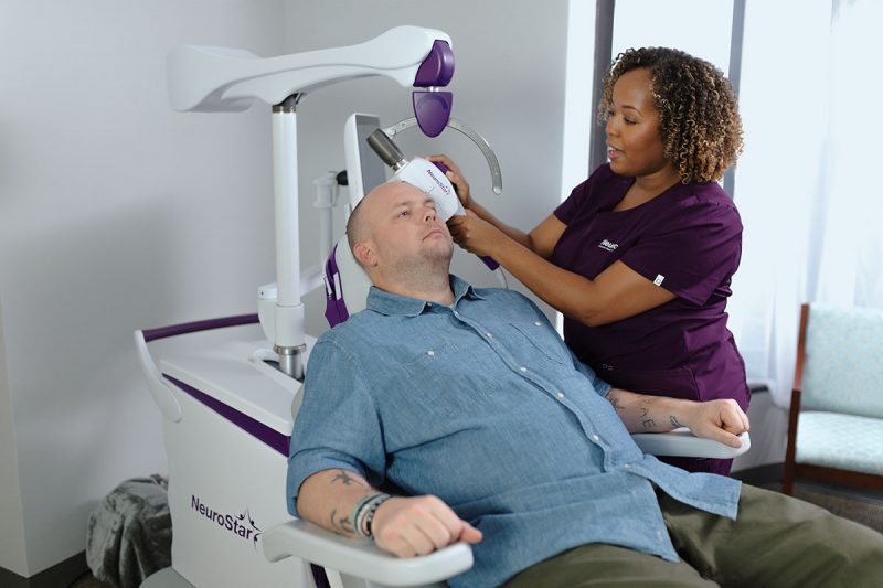 Patient in NeuroStar chair with care team